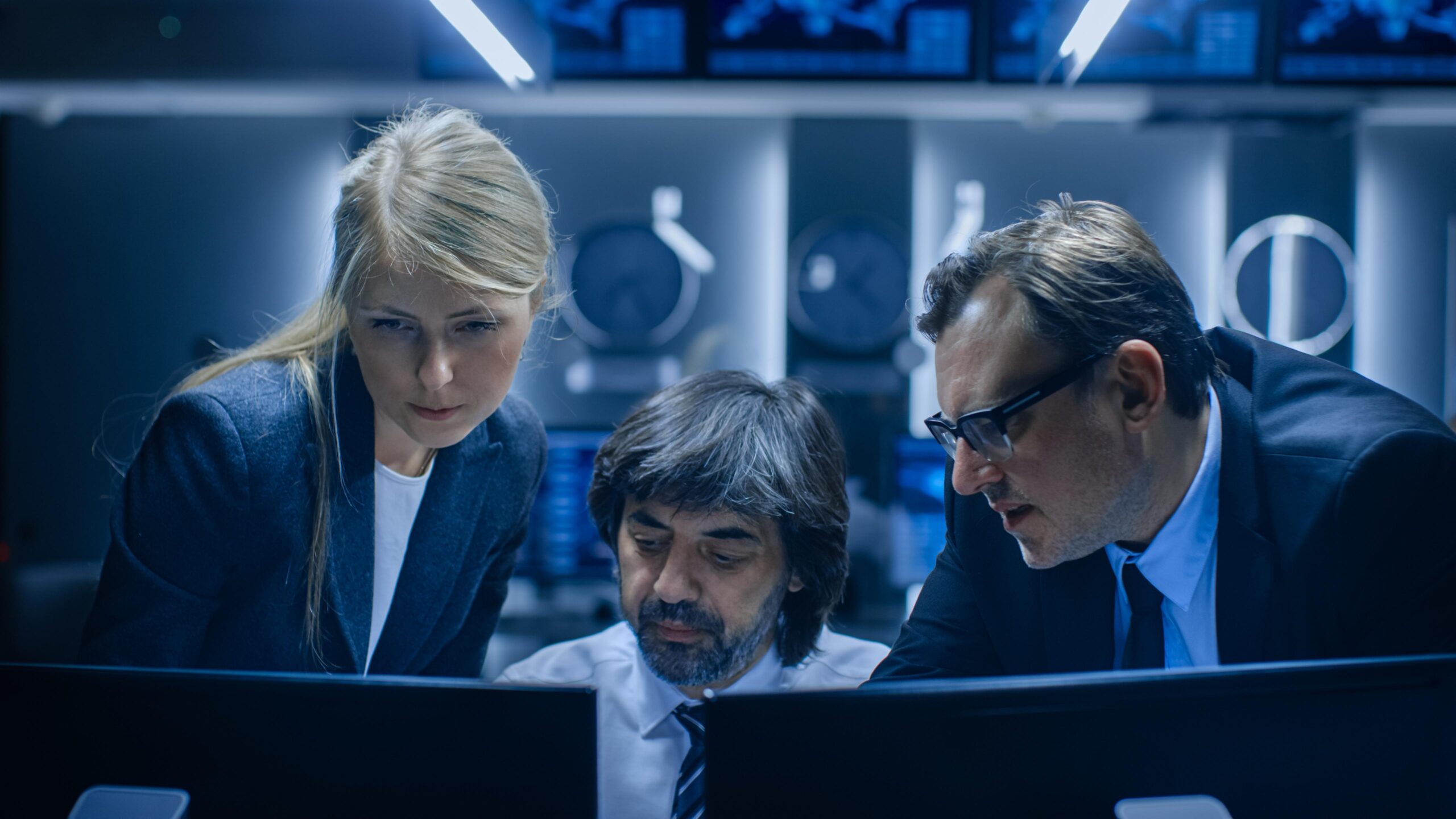 three people looking computer screen